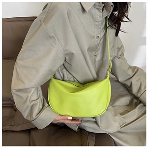 Detail of neon green PU leather crescent shoulder bag showing soft texture and strap