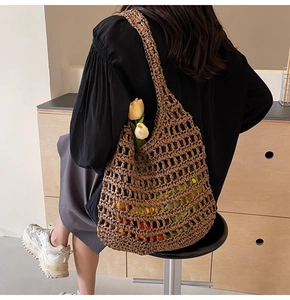 Brown woven straw mesh tote bag with large hollow grid design worn by a model