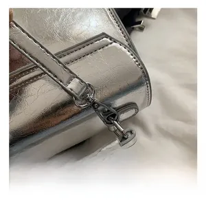 Detail showing the shiny silver metal hook and textured PU leather of the backpack