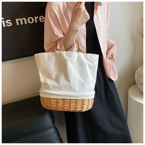 Detail showing natural straw weave base and white canvas stitching on French style tote
