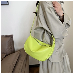 Detail view of neon green PU leather crescent shoulder bag with smooth zipper closure