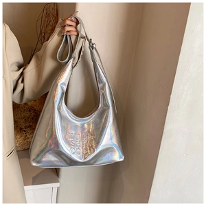 Dettaglio ravvicinato di borsa hobo olografica argento con scritta in rilievo e tracolla