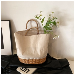 Close-up of a canvas patchwork woven basket handbag with natural wicker base and daisies