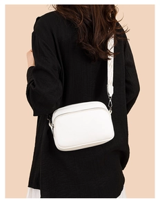 Detail of white litchi textured camera bag with adjustable geometric jacquard strap