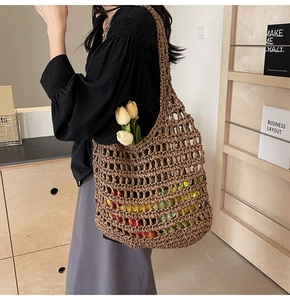 Detailed side view of brown straw woven mesh tote bag showing spacious hollow net texture