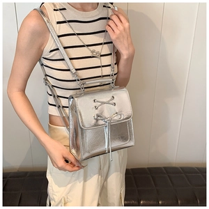 Silver metallic PU backpack with ribbon bow detail shown on model for a trendy chic style