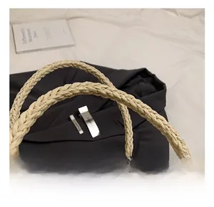 Detailed macro view of the artisanal woven straw texture on this minimalist shoulder bag