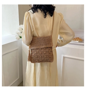 Detailed straw woven crossbody bag with wave patterns and long bohemian tassels