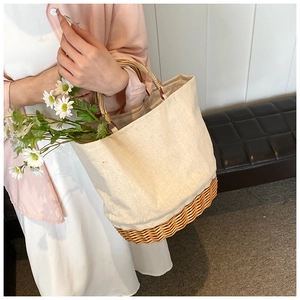 Close-up of woven straw base and canvas tote bag with bamboo round handles for women