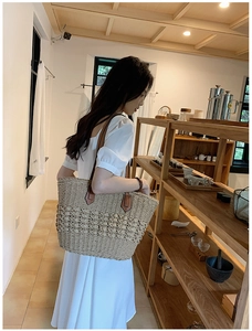 Gros plan du sac cabas en paille tissée avec bandoulière en cuir marron au style élégant