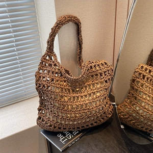 Brown hand-woven straw tote bag with cut-out mesh design and inner fabric liner