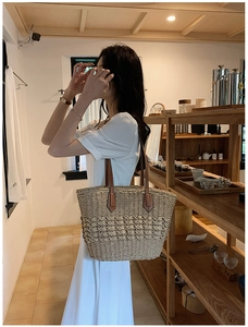 Détails de la texture en paille tressée et bandoulière en cuir d'un sac cabas