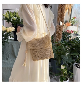 Detail of hand-woven straw crossbody bag with elegant fringe and wooden beads