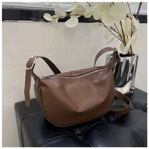 Minimalist dark brown half-moon crossbody PU leather bag with silver zipper and adjustable strap