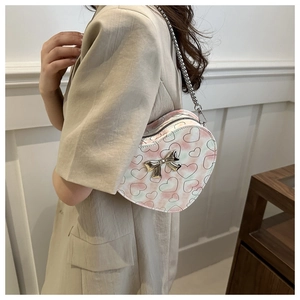 Détail du sac bandoulière cœur en PU avec motifs imprimés et nœud décoratif argenté