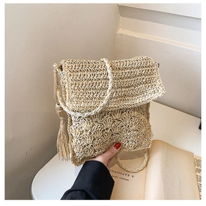 Handmade beige straw crossbody bag with wavy weave texture and long tassel decoration