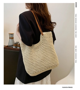 Detail of beige knitted mesh tote bag with brown leather shoulder straps and metal rivets