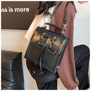 Detail of black PU leather shoulder bag featuring a vintage bow knot and top handle