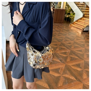 Detail view of shimmering gold and silver sequins on a luxury chain crossbody bag