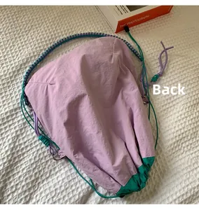 Détail du sac seau en nylon lavande avec sangle tissée tricolore et base en patchwork vert