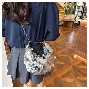 Detail of silver crescent bag with large mirror sequins and metallic chain strap