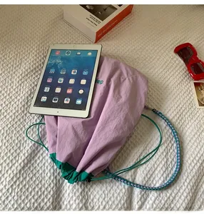 Détail d'un sac en nylon violet avec base verte et broderie dep et cordon