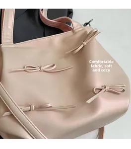 Detail of soft pink pearlescent PU leather handbag with elegant bow decoration