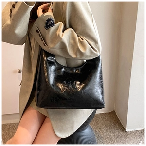 Dettaglio ravvicinato della scritta MUJI PHEN GOOD goffrata su borsa a tracolla in pelle PU nera