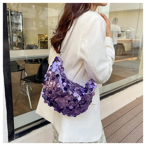 Close-up of purple sequin crescent shoulder bag with silver chain on white blazer