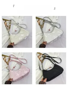 Detail view of the fabric shoulder bag in beige, silver, pink, and black butterfly print