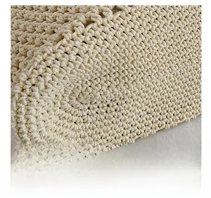 Close-up of cream white knitted fabric showing detailed diamond texture on a shoulder bag