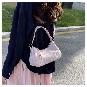 Detail of pink jacquard fabric handbag with butterfly embroidery and crossbody strap