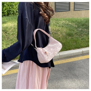 Detailed close-up of a light pink floral crossbody bag with decorative round wooden bead