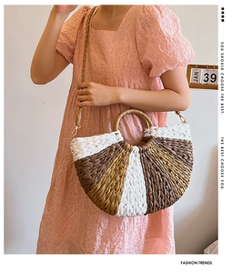 Detailed close-up of a three-color woven straw handbag with a round handle and metal strap