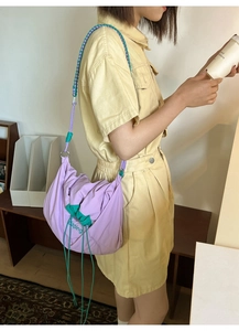 Détail du sac en nylon violet avec bordure verte et bandoulière en corde tressée tricolore