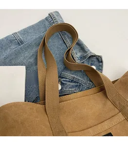 Detail of durable woven handles and canvas texture on a stylish brown tote bag
