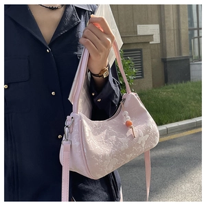Close-up of pink fabric bag with butterfly jacquard and creative pearl bead pendant