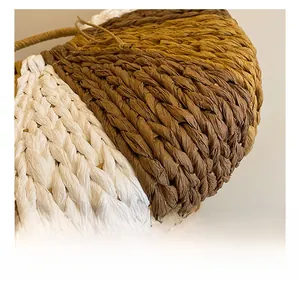 Detail showing the intricate three-color tight woven texture of the straw handbag