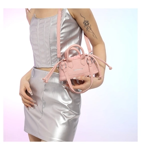 Detail der rosa PU-Leder Mini-Umhängetasche mit Kordelzug und metallischem Logo