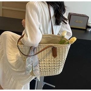 Detail showing high-capacity straw tote with leather handles and printed silk scarf