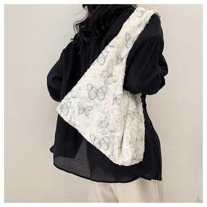 Detailed view of the butterfly jacquard fabric texture on a white hobo shoulder bag