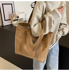 Detail of camel canvas tote bag with front pocket shown on model for daily commute