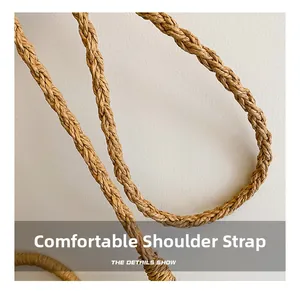 Close-up detail of the comfortable woven straw shoulder strap on the stylish handbag