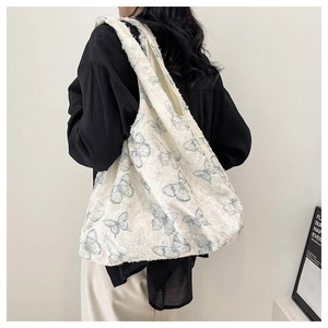 Close-up of white plush tote bag with light blue butterfly patterns on female model