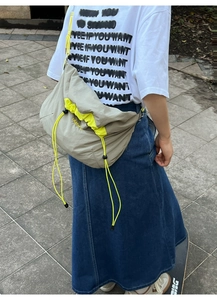 Vue détaillée du grand sac bandoulière en nylon avec cordon jaune fluo et texture grise