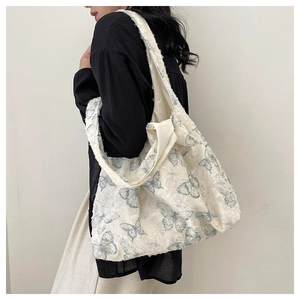 Close-up of lace tote bag featuring blue butterfly jacquard and frayed edge details