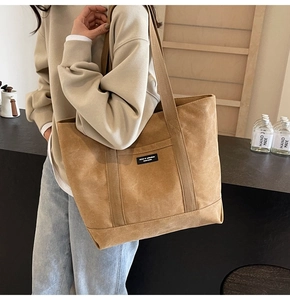 Detailed macro view of trendy khaki canvas tote bag with woven label on shoulder strap