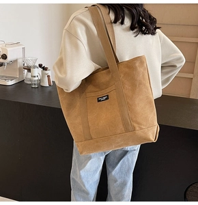 Detail of khaki canvas tote bag showing thick durable fabric and branded woven label