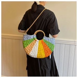Detail of multi-color woven straw bag showing handmade texture and long shoulder strap