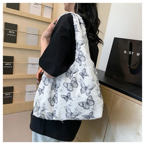 Detail of white lace tote bag with black butterfly prints and seamless shoulder strap